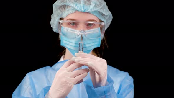 Professional Female Doctor Holds a Syringe with a Vaccine on a Black Background alt