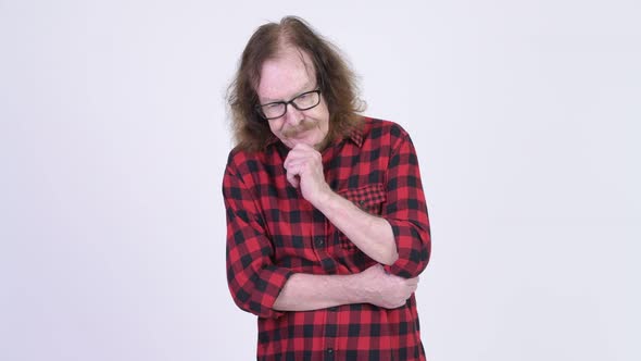 Serious Senior Hipster Man Thinking While Looking Down alt