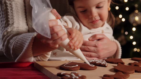 Mother and Daughter Decorating Gingerbread at Home