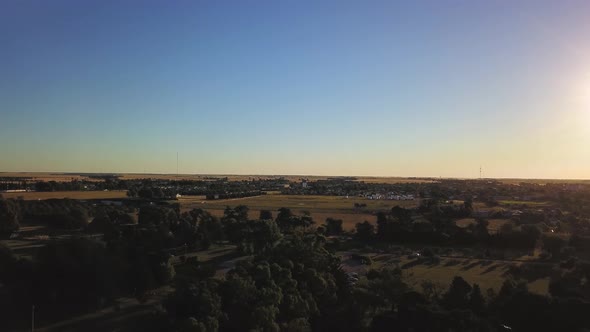 Aerial Drone view going up in little agricultural town during sunset, in Coronel Dorrego, Argentina alt