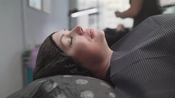 A Beautiful Darkhaired Girl Lies on the Sofa in the Office of the Eyelash Master alt