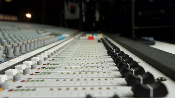 Macro Slide Shot of a Sound Producer Hand is Using a Music Mixer with Editing