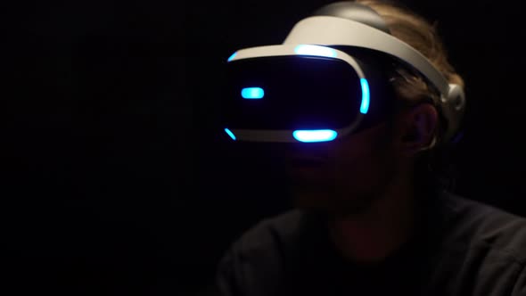 Portrait of Excited Young Man Wearing Modern Goggles and Interacting with Virtual Reality While alt