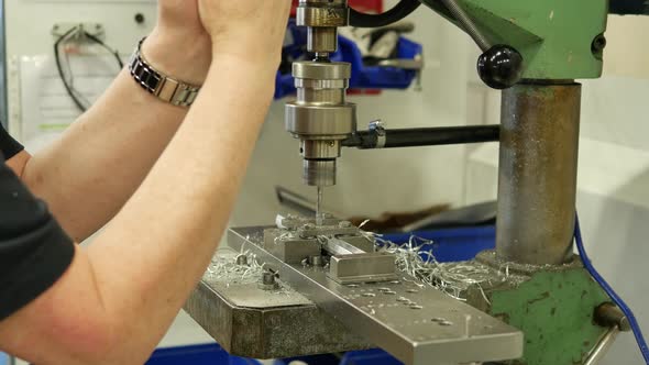 Worker making holes in metal plates with a punching drilling machine alt
