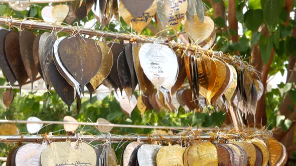 Metal Leaves with Wishes Near Temple. Rack with Traditional Metal Leaves with Wishes Located Near alt
