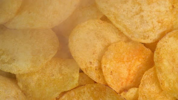 Crispy hot potato chips with smoke rotating in macro. Golden fried potatoes close up. Potato snack alt