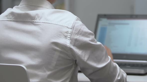 Back View of Female Manager Working on Laptop, Feeling Lower Back Pain, Health