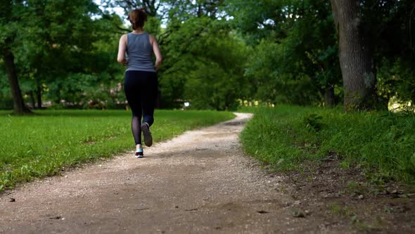 Girl Running in a Green Summer Park