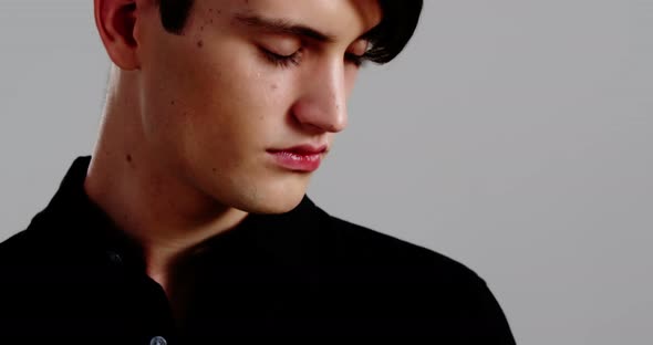 Androgynous man posing against grey background alt