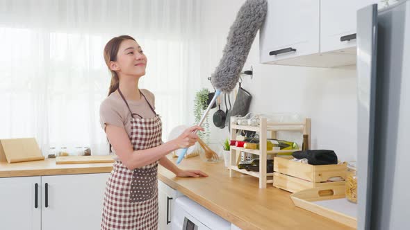 Asian cleaning service woman worker use duster wiping messy dirty for housekeeping housework. alt