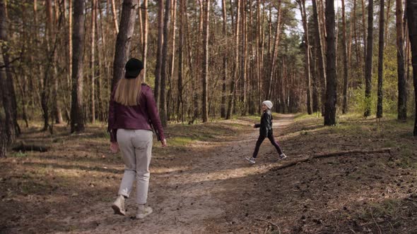 Mother and Daughter Walk Together in the Forest. 