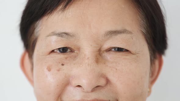 Closeup of Eyes of Mature Asian Woman Smiling to Camera