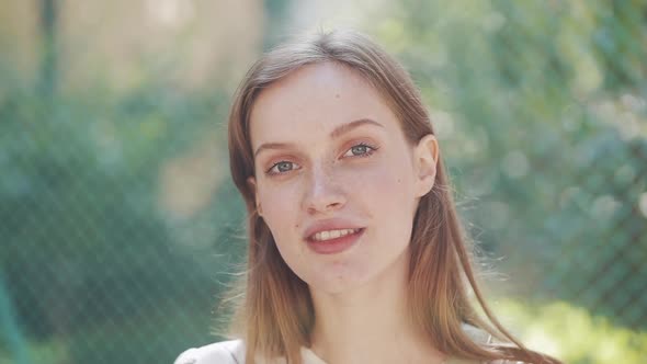 Close Up Portrait of Young Attractive Girl with Brown Hair and Blue Eyes and Freckles Looking To