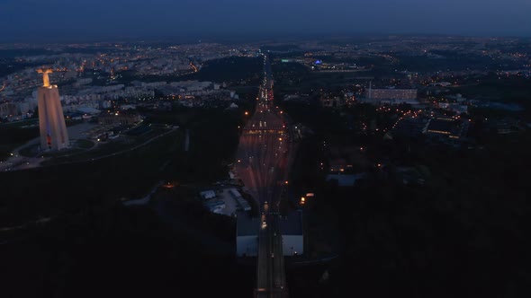 Night Aerial View of Busy Multi Lane Highway and Santuario De Cristo Rei White Monument on the Coast alt