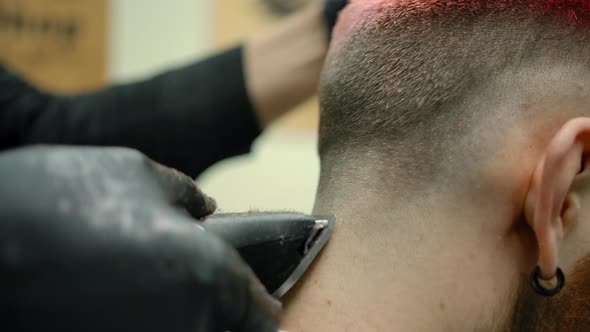 Hair Cutting with Trimmer on the Head of Customer with Pink Hair alt
