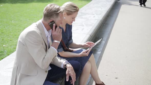 Two colleagues having informal meeting in front of office building alt