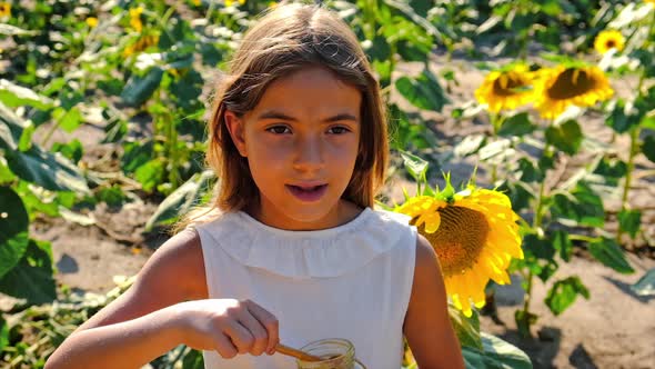 A Child Eats Honey From Flowers alt