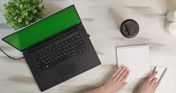 Above Shot in Move Woman Using Laptop Computer on Office Table Background. Girl Makes Notes and