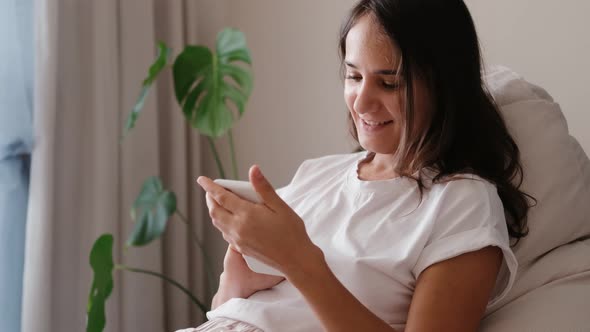 Happy Relaxed Young Woman Holding Smartphone Looking at Mobile Phone Screen Laughing Enjoying Using alt
