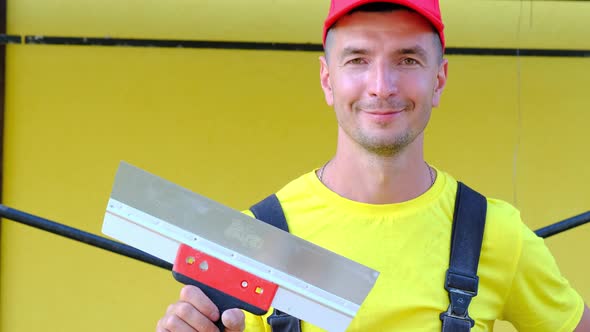 Portrait of a house repair and construction master with a close-up tool. A builder with a spatula in alt