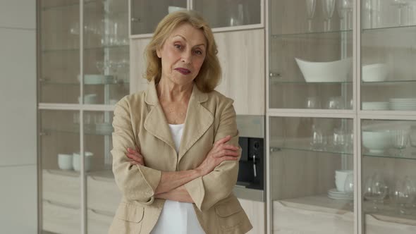 Happy Pensioner Resting at Home Smiling at the Camera Posing Against the Background of the Kitchen alt