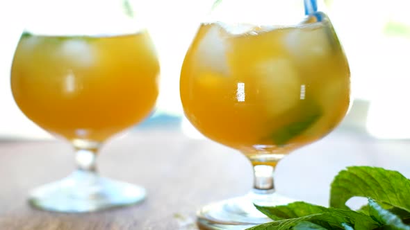 Swirling a mint infused kombucha drink with striped blue straw; high-key static alt