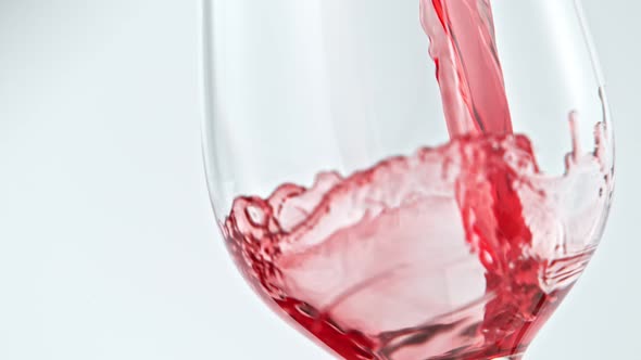 Pouring Red Wine in Super Slow Motion on White Background alt