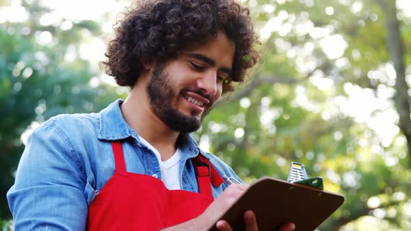 Gardener thinking and writing on clipboard alt