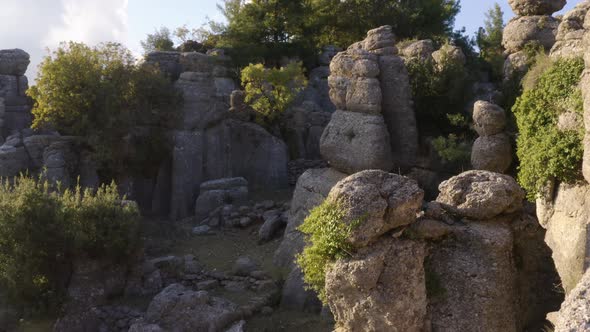 Drone View of Majestic Rock Formations with Green Plants and Coniferous Trees alt