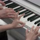 A Close Up Slow Motion Shooting of Hands of an Adult and a Kid Playing Music on the Piano at the - VideoHive Item for Sale
