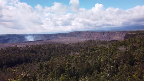 Super wide handheld panning shot of the Kilauea volcano with smoke rising from the cauldron on the B alt