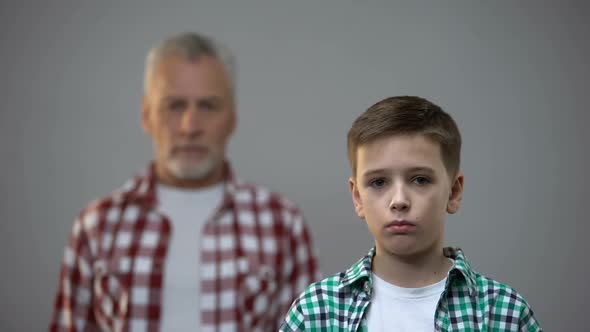 Serious Teen Boy Looking at Camera, Aged Male Behind, Connection With Ancestors alt