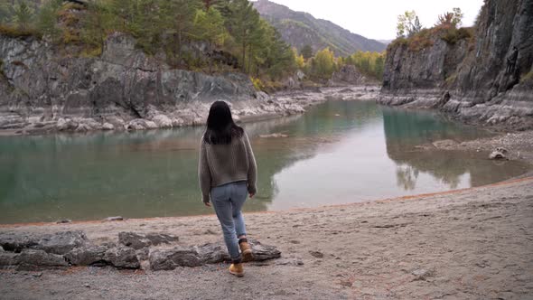 Beautiful Girl with Black Hair a Tourist Walks Along the River alt