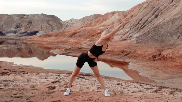 Woman working out on lifeless dried locality