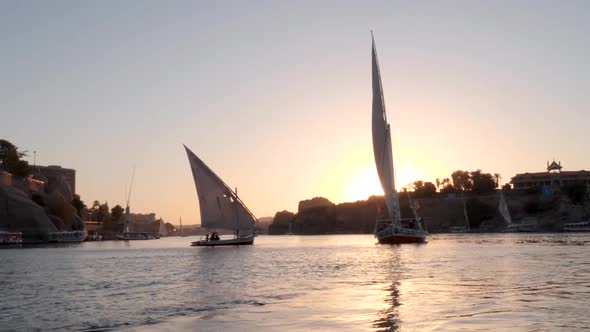 View of two feluccas during sunset sailing on the Nile river in Aswan, Egypt. alt