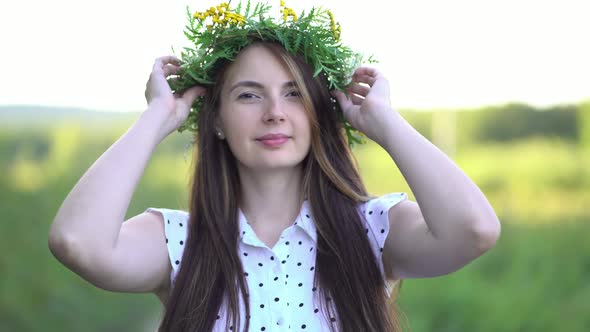 Woman Puts a Wreath of Wild Flowers on Her Head