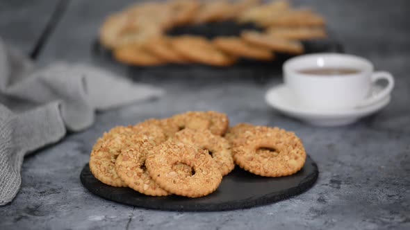 Shortbread Cookie Ring with Peanuts and Cup of Tea on Wooden Table