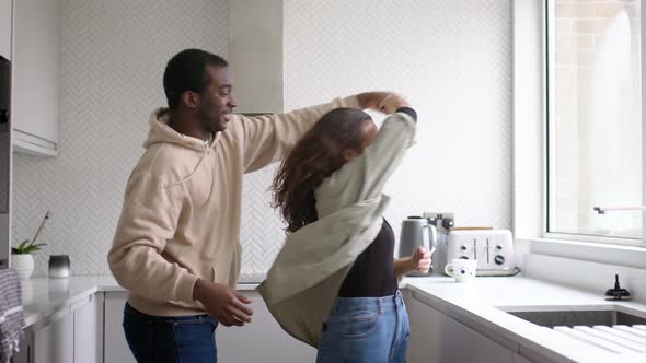 Loving Young Couple At Home Dancing In Kitchen Together