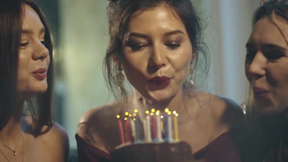 Asian Girl in Party or Birthday Cap Making Wish at Holiday Party in Apartment or House alt