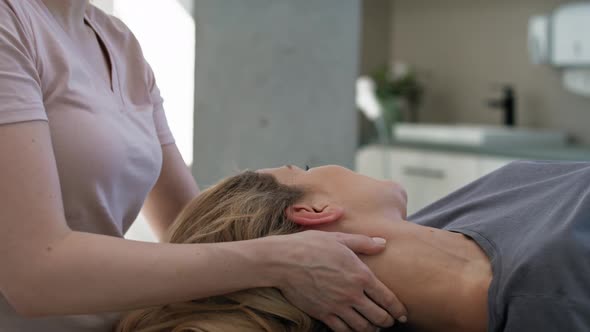 Close up female physical therapist massaging her patient. Shot with RED helium camera in 8K. alt