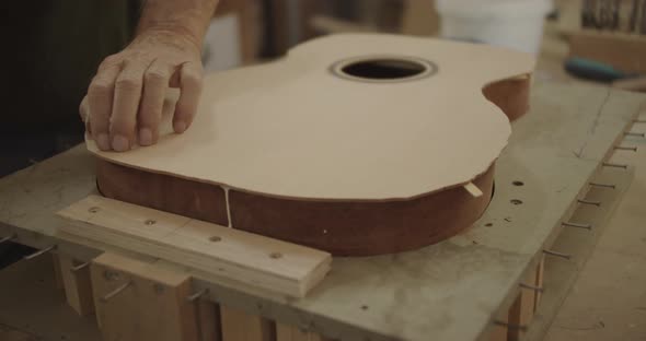 Luthier securing glued guitar part