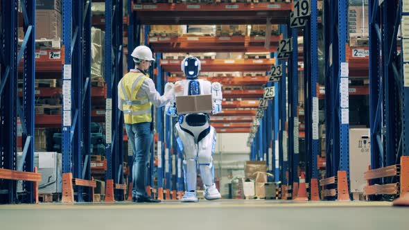 Warehouse Worker Working with Delivery Robot alt