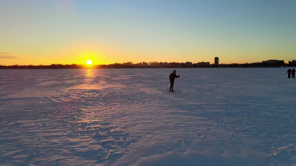 skiing over a frozen lake during sunset, minneapolis minnesota winter sports, enjoying out doors, tr alt
