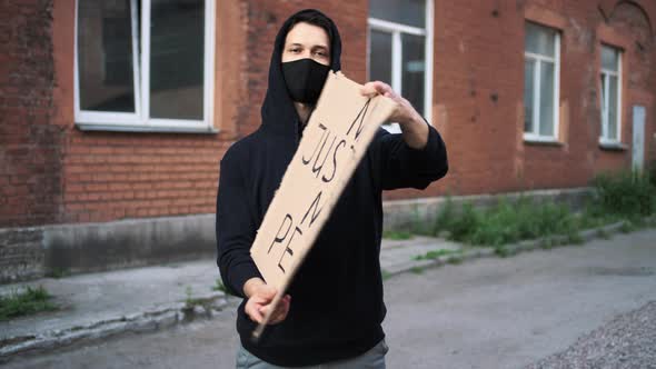 Man in Mask Stands with Cardboard Poster in Hands  BLACK LIVES MATTER
