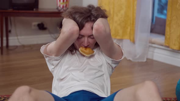 Portrait of Young Skinny 1990s Man Eating Sweet Donut and Pumping Press Looking at Camera alt