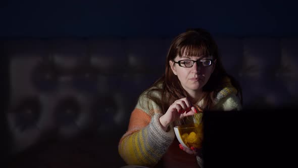 Woman with Excitement Watches Tv and Eats Potato Chips in the Evening at Home