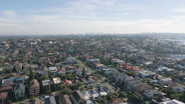 Establishing shot of small seaside town in Sydney Australia. Homes, street, green trees in quiet a q alt