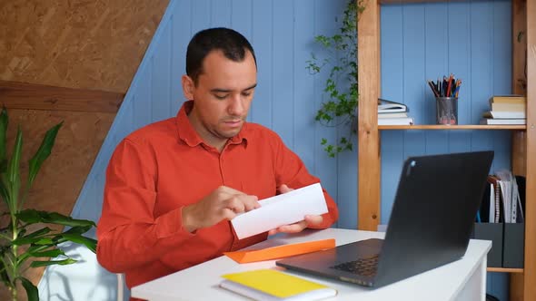 Sad Man Sitting at Home Office Reads Received Bad News Holds Documents Paper Letter