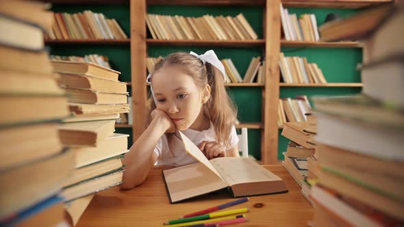 Sad Caucasian Girl in Library Having Some Difficulties During Homework From Book alt