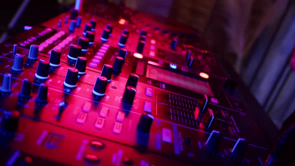 DJ Presses Buttons on Mixing Console with Which Music is Controlled in Nightclub at Party Closeup alt